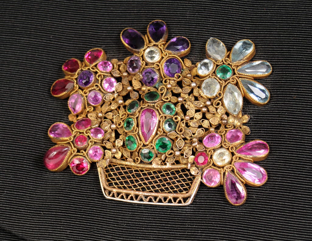 This bag is all about the jewels!  A gorgeous flower basket by Hobe adorns the front of the bag.  The semi precious stones are set in an intricate basket of gold vermeil.  The stones are both faceted and cabochon, and they sparkle brilliantly.<br