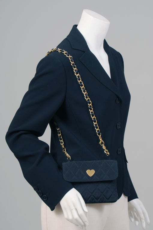 A very witty black crepe jacket from Franco Moschino incorporates a humourous replica of an iconic French shoulder bag into the design.<br />
The three button blazer style jacket in black crepe has a traditional left hip pocket with hand finishing.