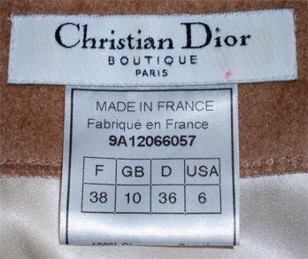 This is a clean classic camel colored sheath day dress by Christian Dior, from 1990's. The dress is sleeveless with two front flap pockets, a silk lining, princess seams, a back slit, and a zipper up the back.<br />
<br />
This camel sheath dress