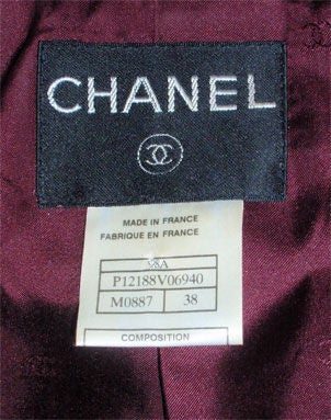 This is a 2pc plum with flecks of blue wool blend jacket and skirt set by Chanel, from 1998A. The jacket is double breasted with logo buttons, two front flap pockets, ruffle layered Sleeve detail, interior chain, and a high collar.

Elizabeth