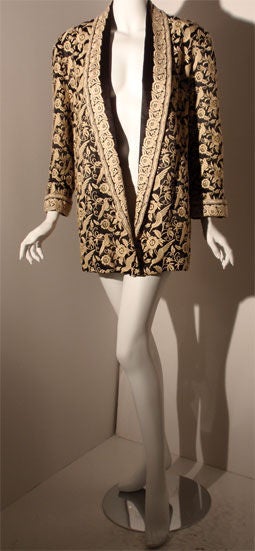 This is a black silk coat with cream embroidered flowers and birds by Norma Kamali, from the 1980's. The coat has two slit side pockets and a black silk belt.<br />
<br />
This black silk and cream coat by Norma Kamali is available to be viewed