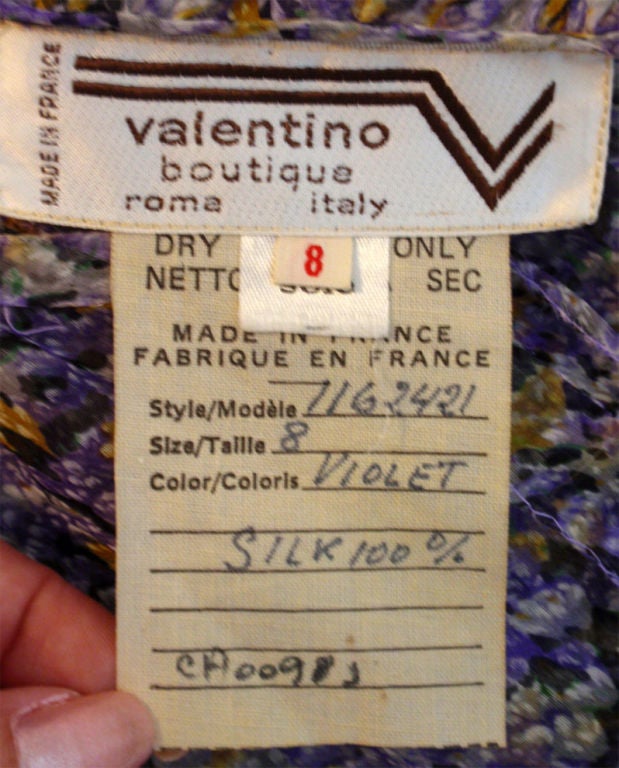 This is a long lavender silk floral day dress with a belt by Valentino Boutique, from the 1980's. It has a tie belt, a large ruffle all around the shoulders, and pleats at the waist.

Elizabeth Mason

The Paper Bag Princess, Inc.
