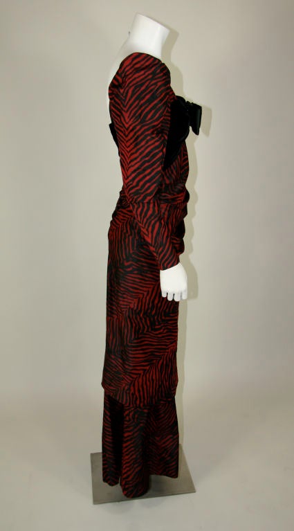 Givenchy (Nouvelle Boutique) 1980s red & black tiger stripe taffeta gown. Bodice has black velvet around the bust and covers the top back. The front has a big satin bow. The body bustles in the back over a full length skirt. It gathers in the front