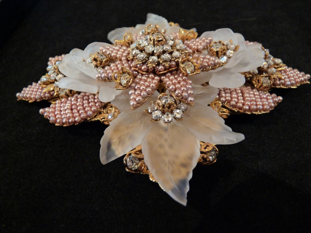 Stanley Hagler pale pink beaded brooch. Layers of pale pink beads on leaf designs with gold leaves rosettes and rhinestones. Clear resin leaves that look like satin glass. Flower on top with pink pearl-like beads and rhinestones. 

ABOUT