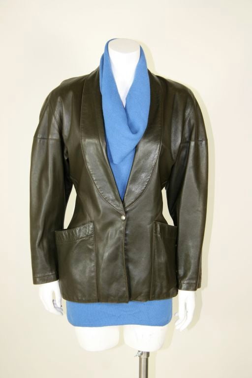 Alaia leather jacket. Structural cut. Low cut collar, with snap closure at the waist. Wide hip deep pockets that open round to the back of the hip. Full sleeves with slouched shoulders. The color is a black, brown, olive mix of a color. Beautiful
