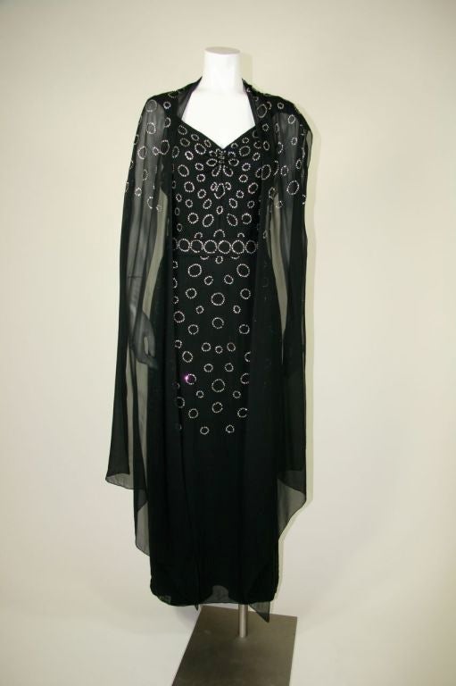 1930s black silk chiffon gown with rhinestone ring pattern from the shoulders to the knees. Gathered at front neck, with spaghetti straps. Over the straps is black chiffon 
