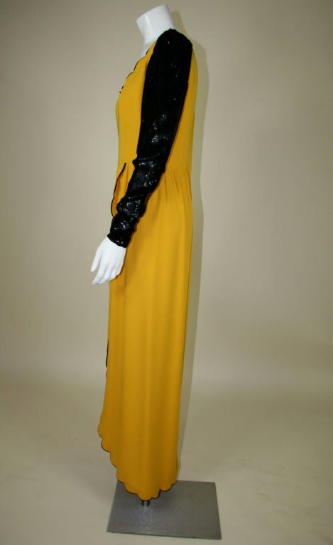 Valentino couture gown. Yellow silk crepe with black silk-satin scalloped edges around skirt and neckline. Full length sleeves sequined all over with zippers at the wrists. Defined waist. The skirt has wrap style slit in the front creating an