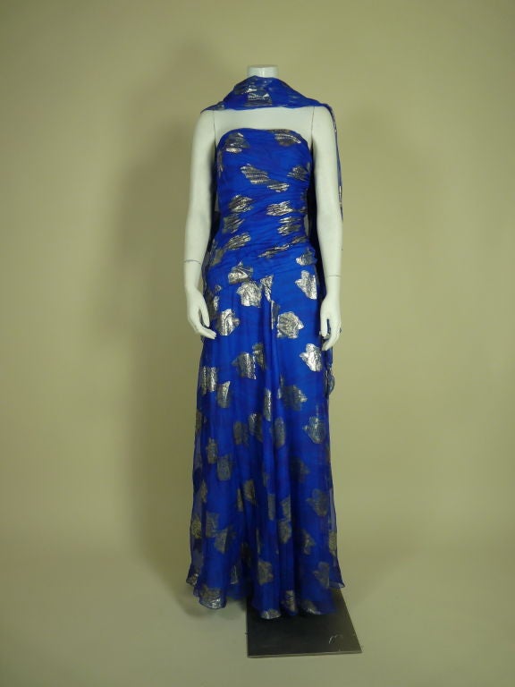 1980s cobalt blue silk gown with gold lame rose motif.  Asymmetrical pleating on strapless bodice. Comes with matching wrap. 

Measurements:

Bust: 32