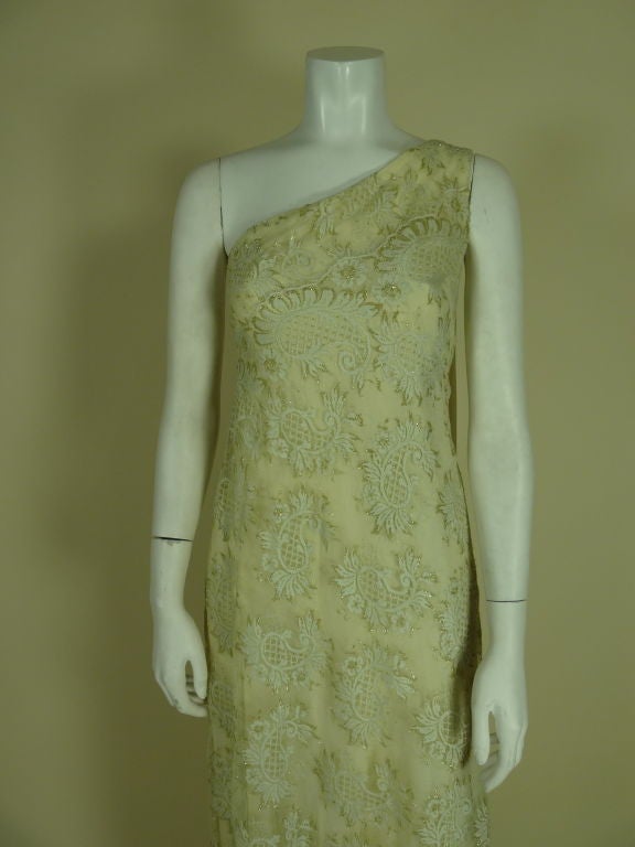 Spectacular asymmetrical sari-style gold metallic lace gown with dramatic, silk-chiffon shoulder drape swag and modified “bustle” in back. Lined with four layers of cream silk chiffon.