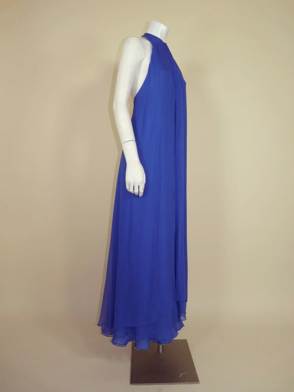 Brilliant blue violet crepe chiffon backless halter gown from George Stavropoulos. A 2-ply layer of chiffon cascades from the front neckline all the way around to the back of the gown giving it a diaphanous feel. The body of the dress is constructed