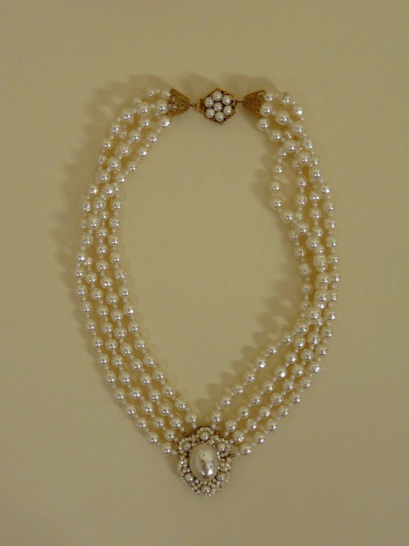 Stunning baroque pearl set from famed costume jeweler Miriam Haskell. Set includes multi-strand necklace with oversized pearl cabachon pendant surrounded by hand beaded mini pearls, matching earrings and diamond shaped brooch. All pieces are mounted