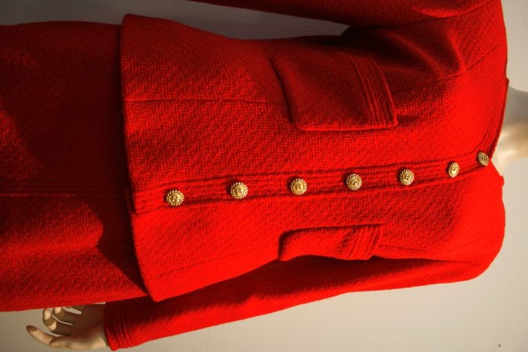 This fantastic Chanel red bouclé suit features a collarless jacket with patch pockets, gold metal buttons silk lining and Chanel's signature chain weighted hem!  The skirt has a three button vent at the hem.  <br />
<br />
Jacket; <br />
Shoulder