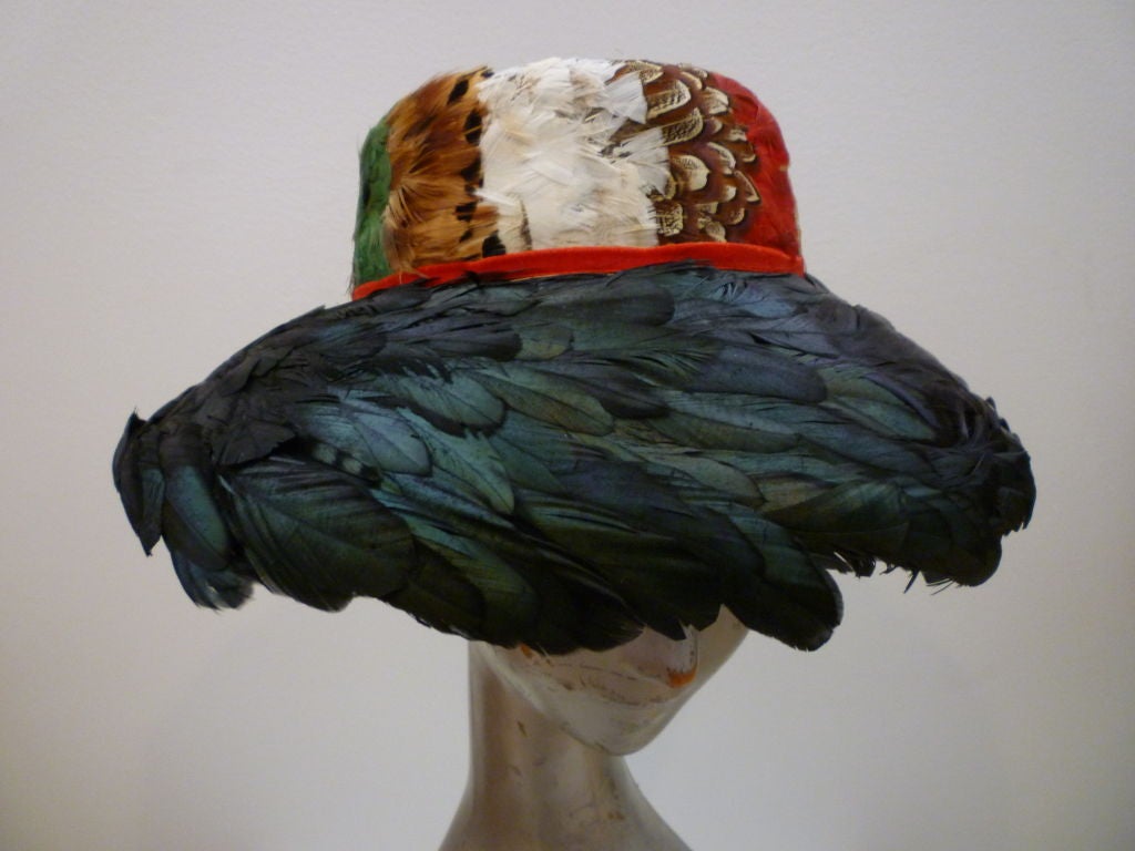 Beautiful 1950s completely feathered hat in pheasant and coq feathers with a red velvet band from Jillé.  Inner band measures 20 1/2