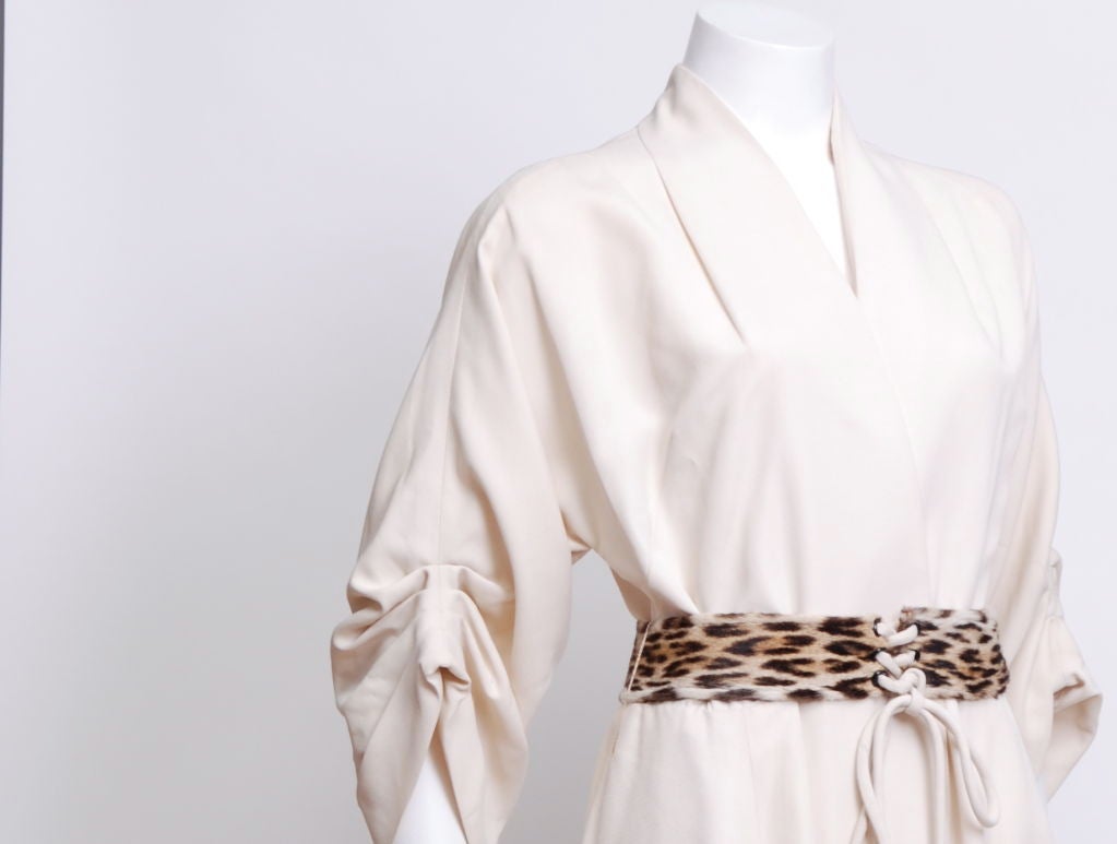 Ivory faille long wrap hostess gown, sleeves have four tucked pleat, leopard fur front lacing belt. This gown is deadstock (never worn with original tag attached).