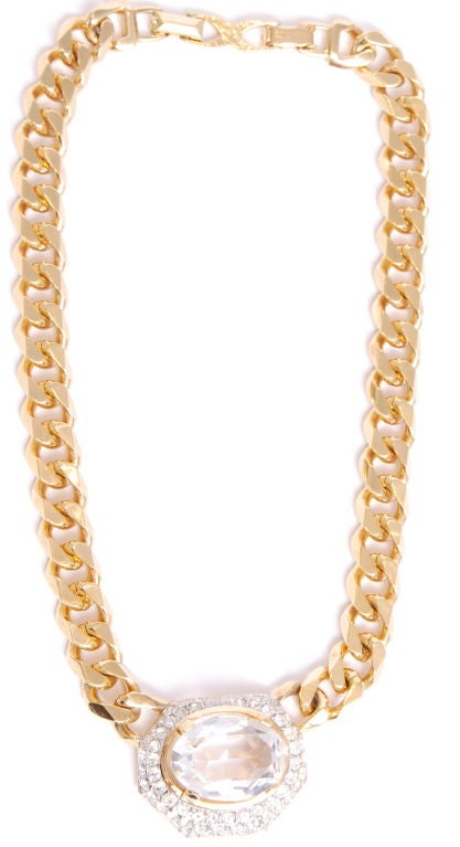 Shiny gold tone flat chain link necklace with rhinestone pendant surrounded two rows of rhinestones.

Total length of chain is 16 inches and pendant is 1.5 inches wide.