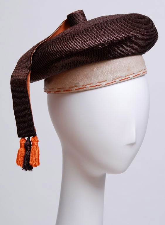 Deadstock Yves Saint Laurent wrapped chocolate straw beret with leather band and orange tassel.