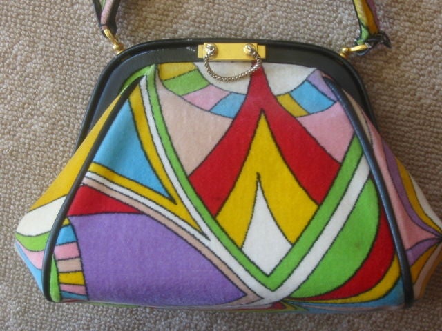 Gorgeous Colorful Print Vintage Purse from EMILIO PUCCI<br />
<br />
This lovely purse is made of soft velour fabric with a colorful geometric print.<br />
<br />
The purse is trimmed with leather and made with a secure closure that is accented