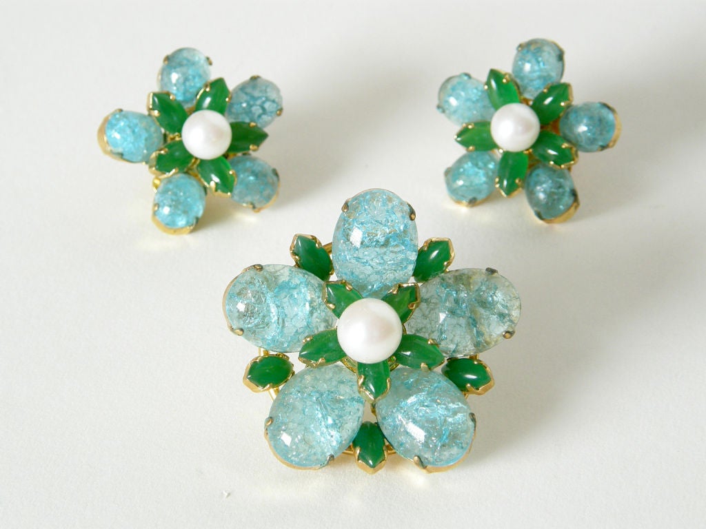 This 1968 pin and earring set was made in Germany for Christian Dior. The construction is very 3-dimensional, with aqua blue crackle glass cabochons, faux jade marquise cabochons and faux pearls set at different heights, giving a depth to the
