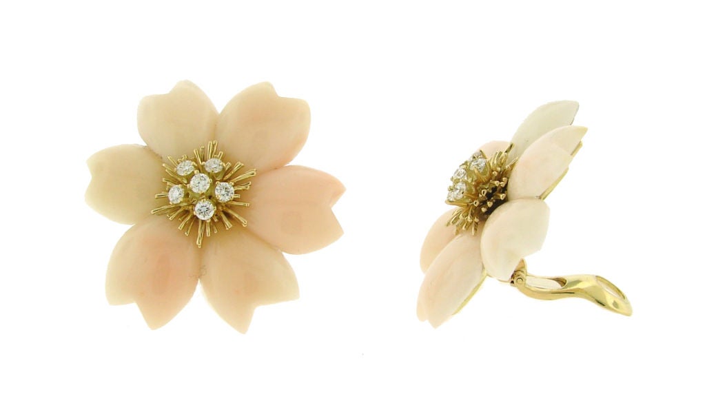 Fabulous flower clip-on earrings were created by Van Cleef & Arpels. The flower head set with carved angel skin coral petals centering upon a brilliant-cut diamond cluster and yellow gold wirework pistils, mounted in yellow gold.