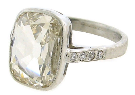 Classic Art Deco solitaire engagement ring made of platinum and set with approx. 2.40 cts transitional cushion cut diamond and diamond accents on the sides (four single cut diamonds on each side).<br />
The cushion cut diamond measures 12 mm x 8.4