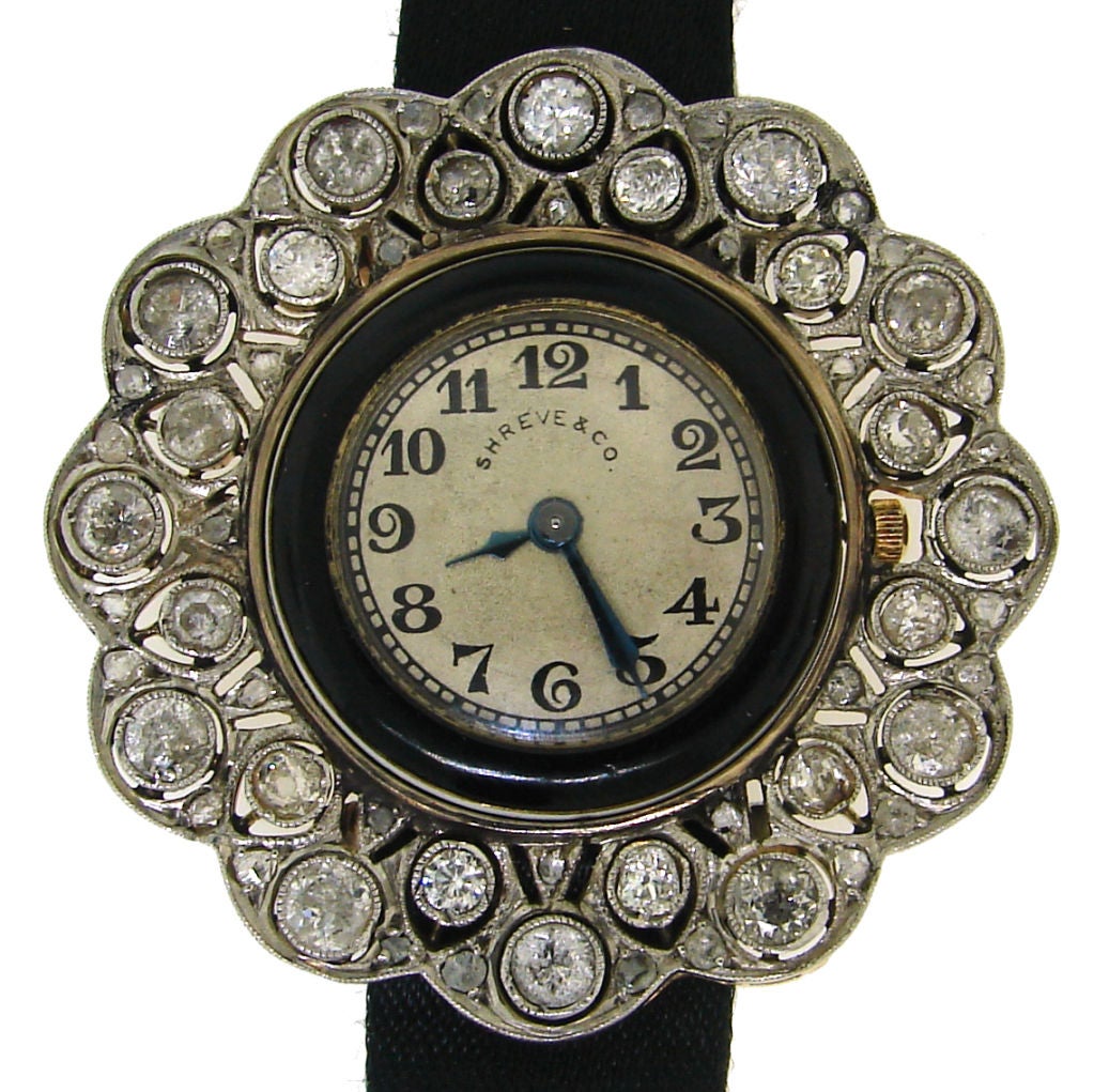 Unique and feminine Art Deco watch created by American company Shreve & Co. in circa 1910's. It is made of yellow and white gold, black and white enamel and set with Old European, old mine and rose cut diamonds. The case is of a pierced floral
