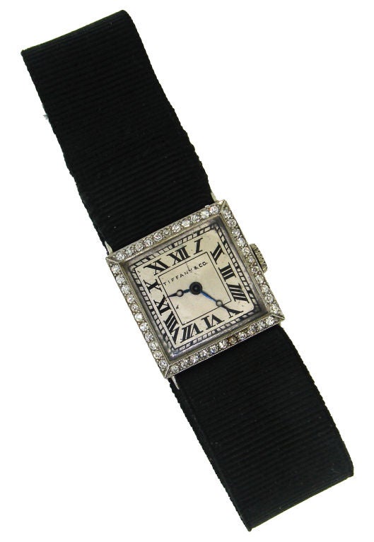Elegant classic Art Deco ladies watch created by Tiffany & Co. in the beginning of 20th century. It has a square face framed with forty four single cut diamonds. The silver color dial has black hand-painted Roman numerals and dark blue hands. The