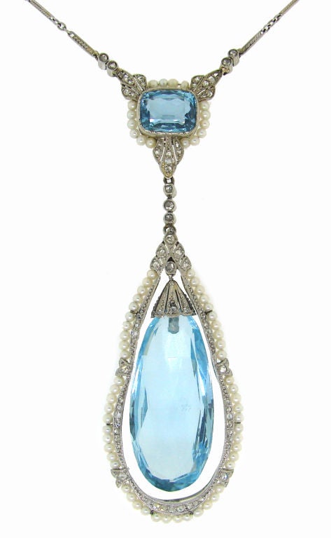 Delicate and elegant Edwardian necklace created in Europe in the 1910's. Gorgeous approx. 14 carat aquamarine briolette is hanging inside a tear-drop shape seed pearl and diamond platinum frame. It is connected to an approx. 3.40 carats horizontally