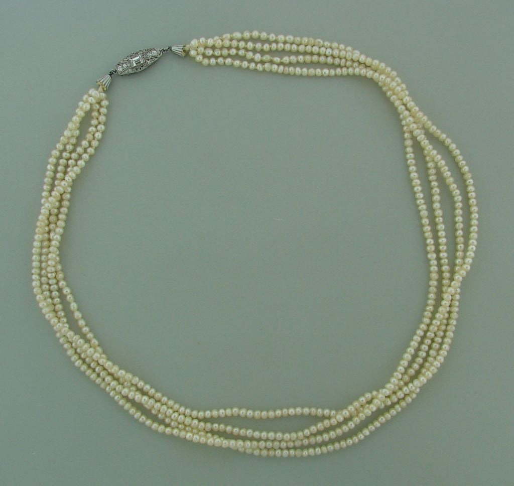 Fabulous Edwardian Tiffany & Co. Four Strand Salt Water Natural Pearl Necklace with Diamond & Platinum  Clasp.<br />
Average size of pearls is 3.1 x 2.2 mm.<br />
Platinum filigree clasp tastefully set with approx. 0.30 ct. emerald cut diamond and