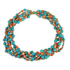 A torsade necklace of turquoise, coral, and gold beads.