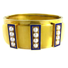 An antique gold cuff bracelet with half pearls and blue enamel