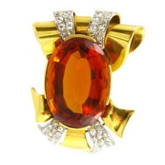 A retro gold and diamond brooch with a central Madeira citrine