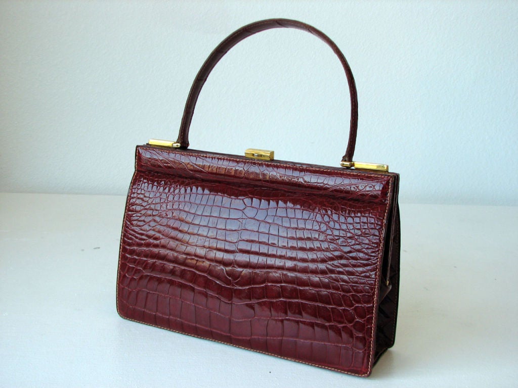Fine & large vintage crocodile 'Kelly' hand bag. Authentic vibrant red skin item fully red leather lined with gilt metal hardware. Pristine interior features 2 open & single zipper pockets. Item retains original matching leather loose coin purse.