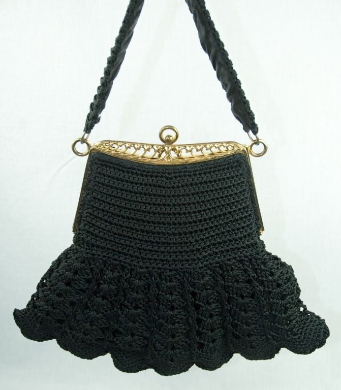 Featured is an extraordinary large black thick crochet purse with gold  tone frame and clasp. The interior is a black satin. Both interior and exterior are pristine.

Measurements:
Height: 9