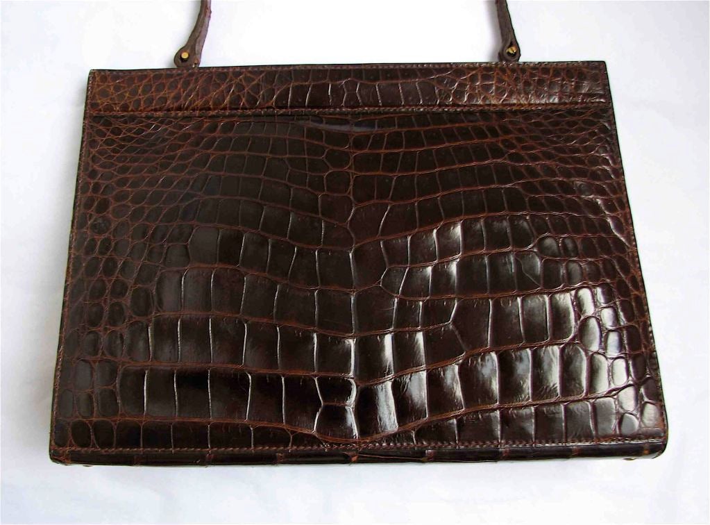 Deep brown Crocodile skin bag made in France for Saks fifth Avenue. One large compartment with 2 side pockets and a coin pocket with clasp. Measures approximately 12.5