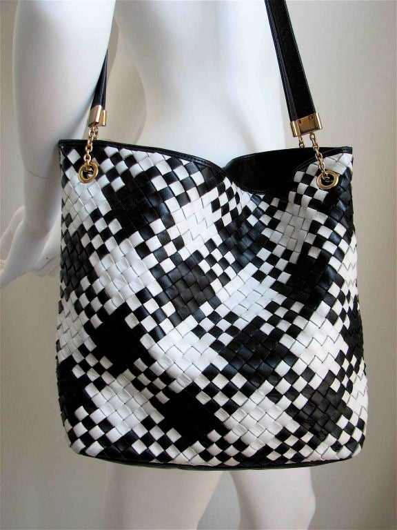 Jet black and stark white 'houndstooth' woven leather bag. Fully lined in black satin. One interior zippered compartment. Gold hardware. Made in Italy. EXCELLENT CONDITION.