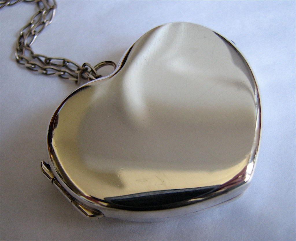 Sterling silver locket with removable liner for solid perfume. Locket be used to display photos or other small objects. Excellent condition.