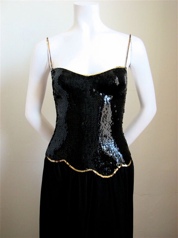 Very rare jet black sequined gown with gold trim from Loris Azzaro dating to the late 1970's. Fits a US 2.  Measures approximately 32" at bust and 25" at waist. Asymmetrical silk skirting. Zips up back. Made in France. EXCELLENT CONDITION.