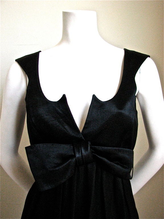 Very short mini dress with large wrap around bow from Thierry Mugler dating to the 1990's. Labeled a French size 36, which fits a US 2 or 4. Jet black satin. Snaps up back. Made in France. Good condition.