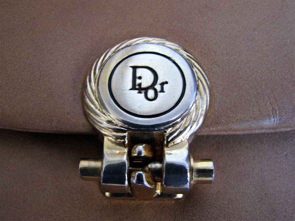 Tan, butter-smooth leather bag from Dior. Adjustable gold chain strap that can be completed concealed. Strap can be converted to one long strap or a shorter double strap. Measures approximately 10.5