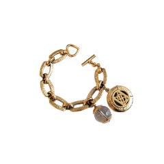 YVES SAINT LAURENT gold bracelet with YSL and rock quartz charms