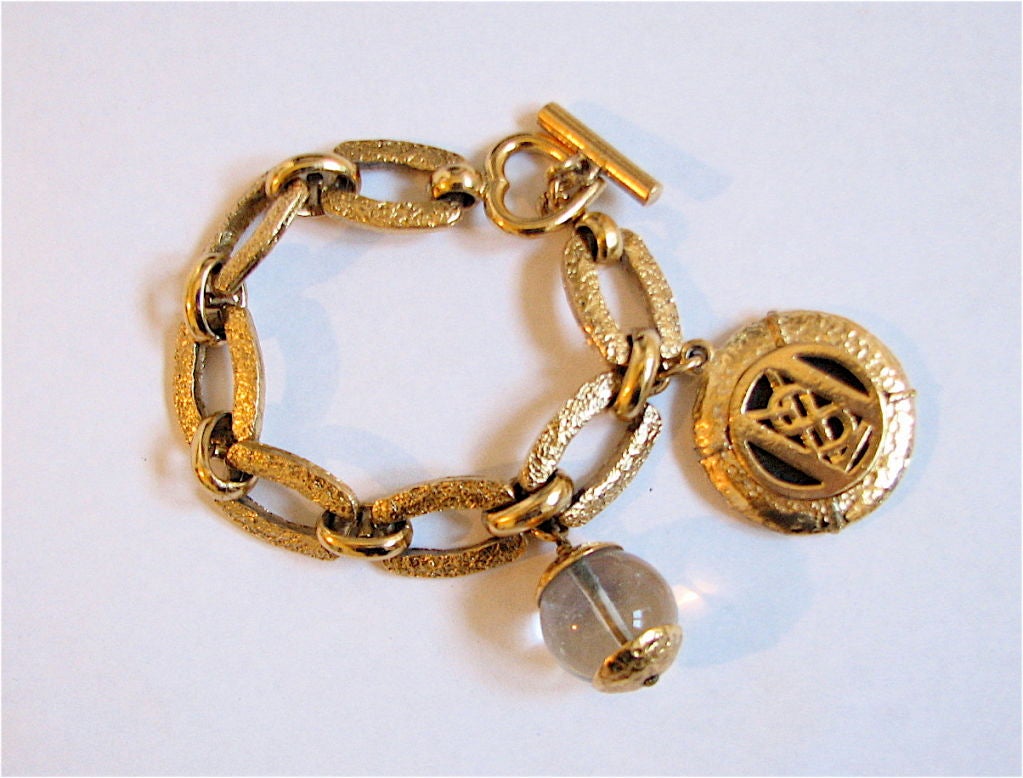 YVES SAINT LAURENT gold bracelet with YSL and rock quartz charms at ...