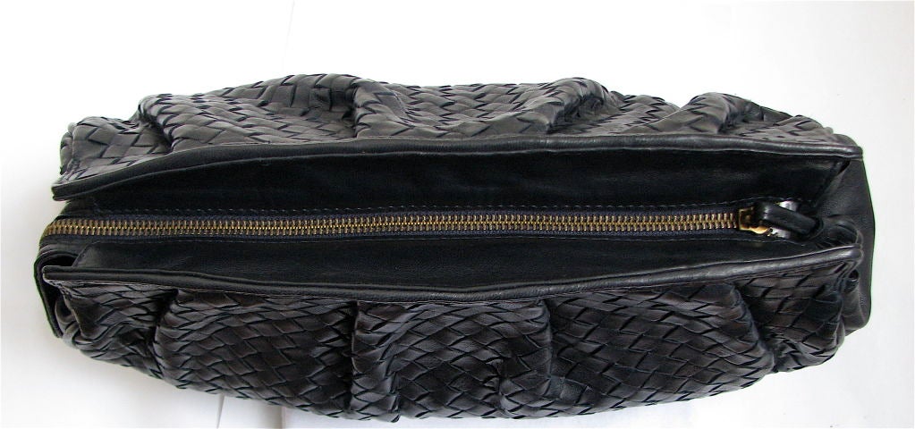 Wonderful navy blue woven clutch with top zipper. Tassel on zipper. Fully lined in navy. One interior zippered compartment. 12
