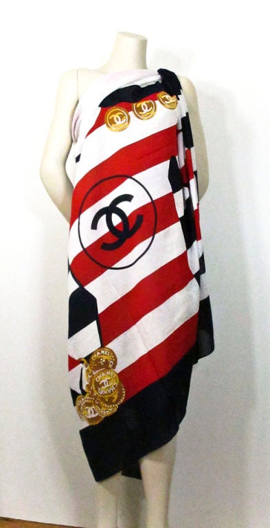 Chanel vintage oversized cotton pareo in a nautical/patriotic color palette.  Print is stripe with a hat-clad female silhouette in contrast stripe top with gold interlock CC logo buttons and a huge gold Chanel charm bracelet.  Navy border with
