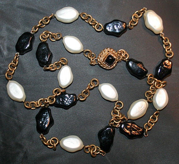 Composed of black freeform Gripoix poured glass, faux baroque pearl beads and gold-tone metal links. The clasp is set with a black poured glass stone with round plaque stamped with 