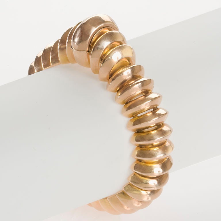 A French Retro 18 karat rose gold bracelet by Jaeger LeCoultre, featuring a hidden face in the raised portion of the ribbed bracelet. Signed, Jaeger LeCoultre.