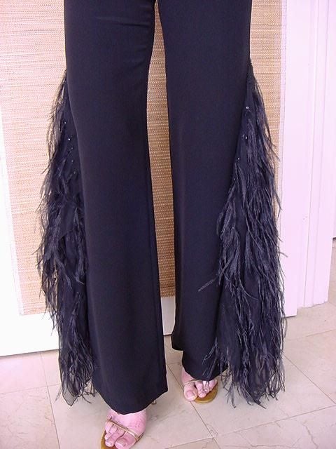 Beyond Fabulous!!!  
Jet black wide leg pant with a straight cut.
From the upper thigh down, a large silk chiffon scarf creates 2 panels.
The scarf is adorned with long Ostrich feathers.
Each feather is tipped with a small black diamante that