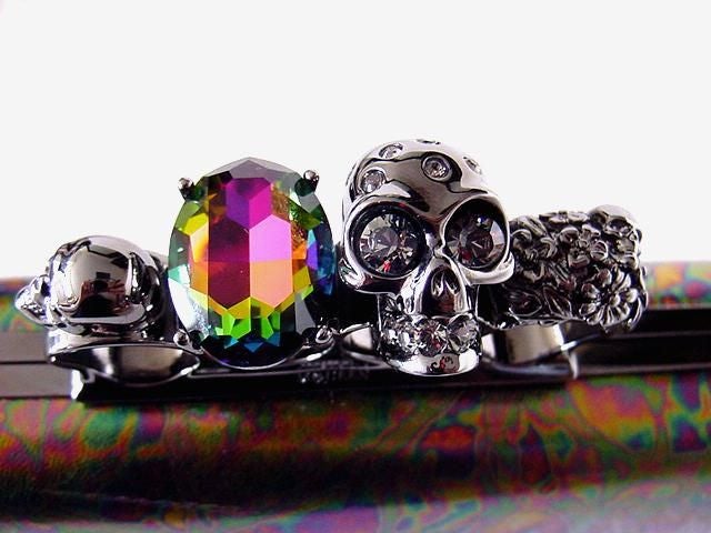 Sold out and just about impossible to find, this is one of the last creations of ALEXANDER McQUEEN.  <br />
Oiled leather with the coveted ringed clutch. <br />
The rings have 3 skulls, 2 of which have diamante eyes. <br />
The large skull also
