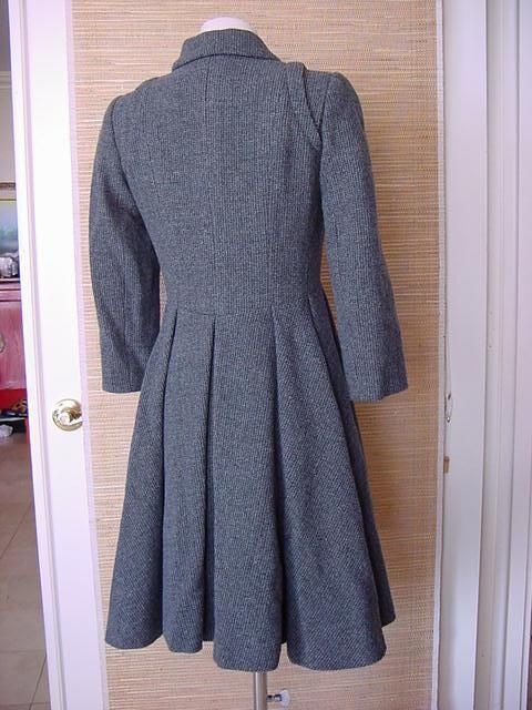 Utterly stunning CHANEL piece.  
Grey on grey tweed 3/4 sleeved coat/dress.
8 Button double breast. 
Two  horizontal flap pockets - each with a working button.
All the buttons have a textured edge with CHANEL on 2 sides.
The other 2 sides have