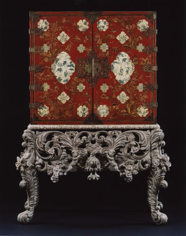 With two cupboard doors decorated with chinoiserie figures and foliage and variously shaped panels decorated en grisaille with landscapes and figures mounted with shaped, pierced and engraved lock-plate, hinges and angles enclosing ten various-sized