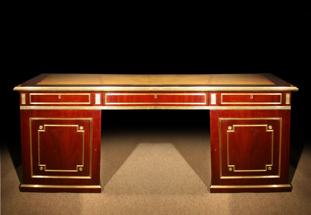 Magnificent Russian neoclassical mahogany pedestal desk enriched with bold brass details often referred to as the “Jacob Style”. The leather top surrounded by a mahogany brass banded border. The frieze with three drawers all with brass trim and